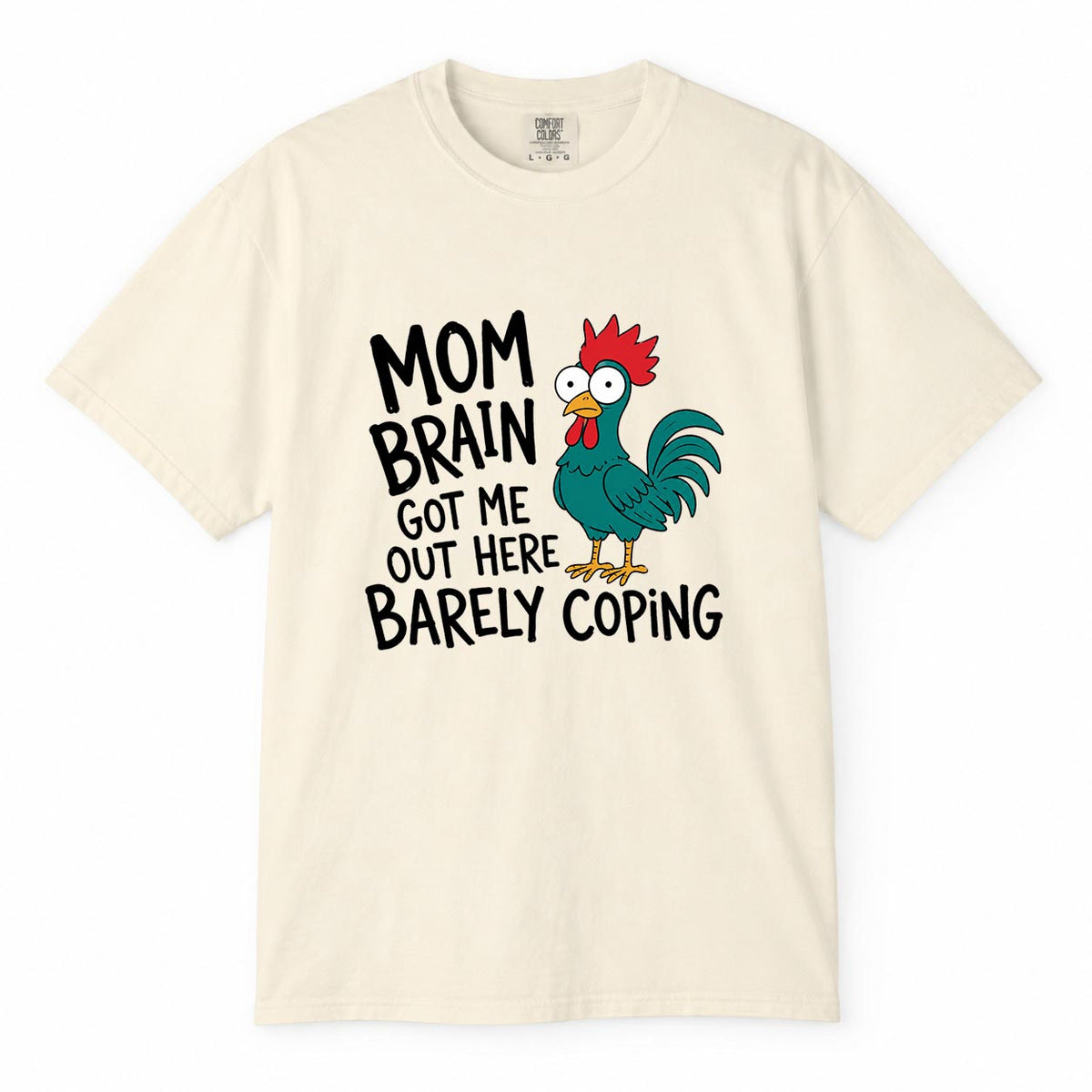Comfort Colors ivory t-shirt with cartoon chicken graphic and "Mom Brain Got Me Out Here Barely Coping" funny tired mom life shirt design